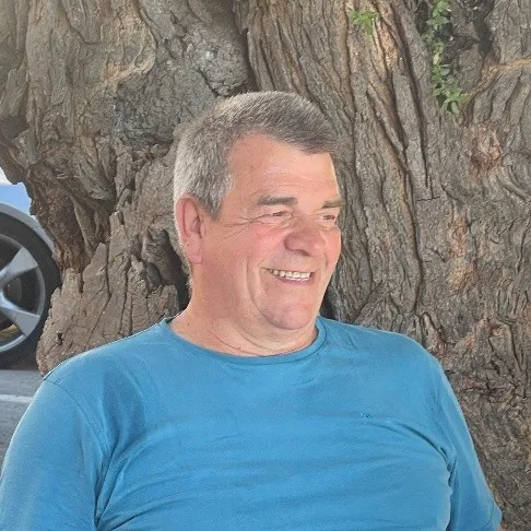 Schröder_Stefan Photo of a man in a blue T-shirt leaning against a tree.