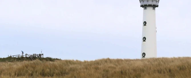 Farol diante de dunas e praia